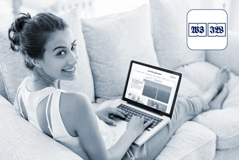 Eine Frau, die auf dem Sofa sitzt und am Laptop ist