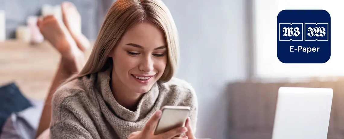 Frau schaut aufs Smartphone mit E-Paper-App