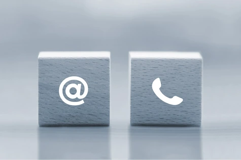 olzwürfel mit einem @-Symbol und einem Telefon-Symbol